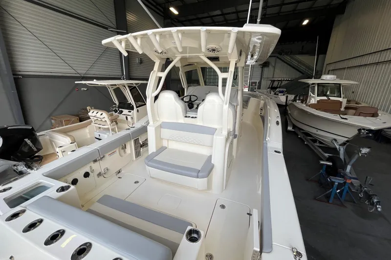 Zippy Yacht Photos Pics 2026 Scout 330 LXF boat interior in showroom, featuring seating and control area.