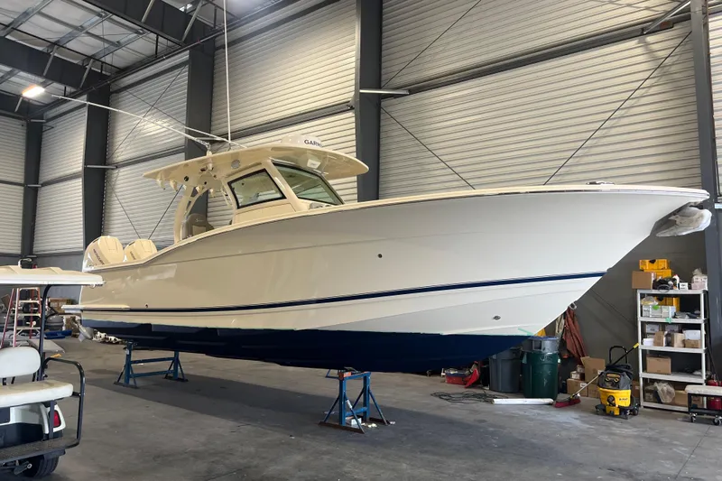 Zippy Yacht Photos Pics 2026 Scout 330 LXF boat in a warehouse, elevated on stands.