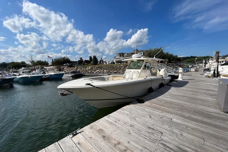 Zippy Yacht Photos Pics 2026 Scout 330 LXF boat docked at a marina under a clear blue sky.