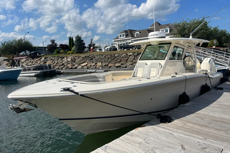 Zippy Yacht Photos Pics 2026 Scout 330 LXF boat docked at marina under blue sky.