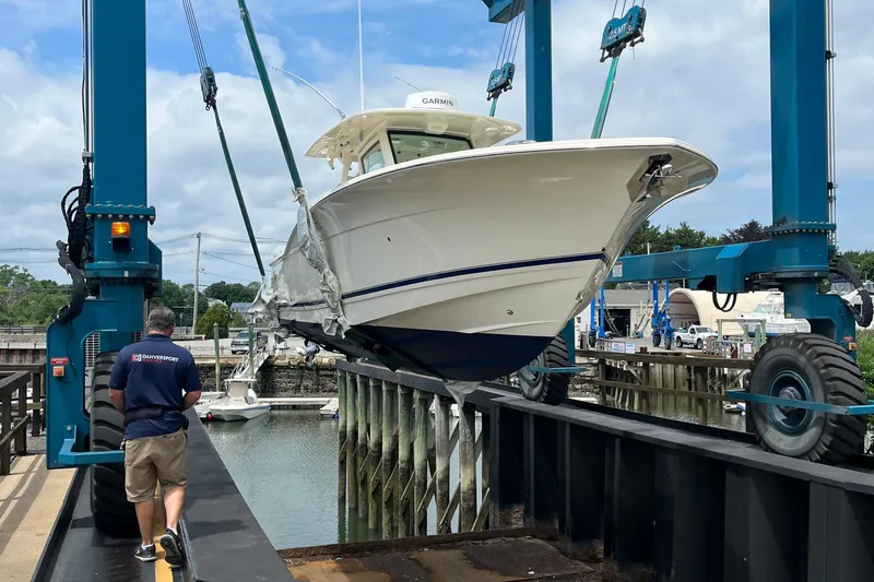 Zippy Yacht Photos Pics 2026 Scout 330 LXF boat being lifted by a crane at a marina.