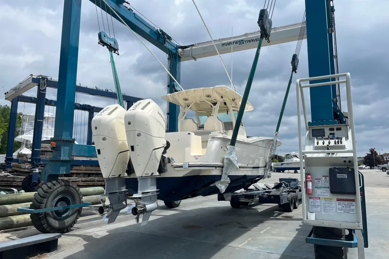 Zippy Yacht Photos Pics 2026 Scout 330 LXF boat on lift, showcasing dual engines and sleek design.