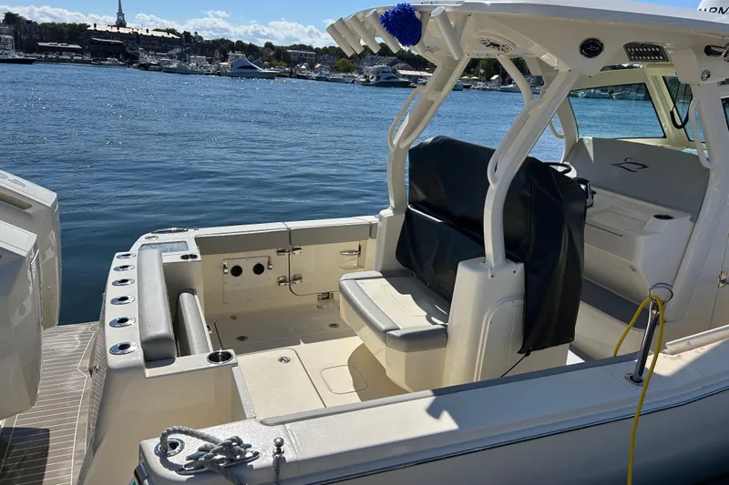 Zippy Yacht Photos Pics 2026 Scout 330 LXF boat interior with seating, docked by the water.