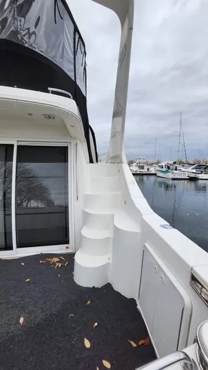  Yacht Photos Pics 2005 Carver 420 Mariner yacht with stairs, docked at marina under cloudy sky.