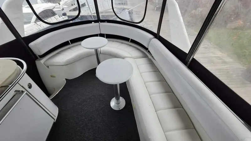  Yacht Photos Pics 2005 Carver 420 Mariner interior with white seating and round tables.