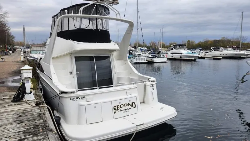  Yacht Photos Pics 2005 Carver 420 Mariner docked at marina, overcast sky, calm water.
