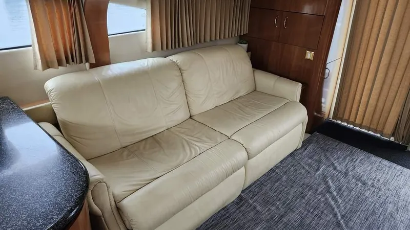 Yacht Photos Pics 2005 Carver 420 Mariner interior with beige leather sofa and wooden cabinetry.