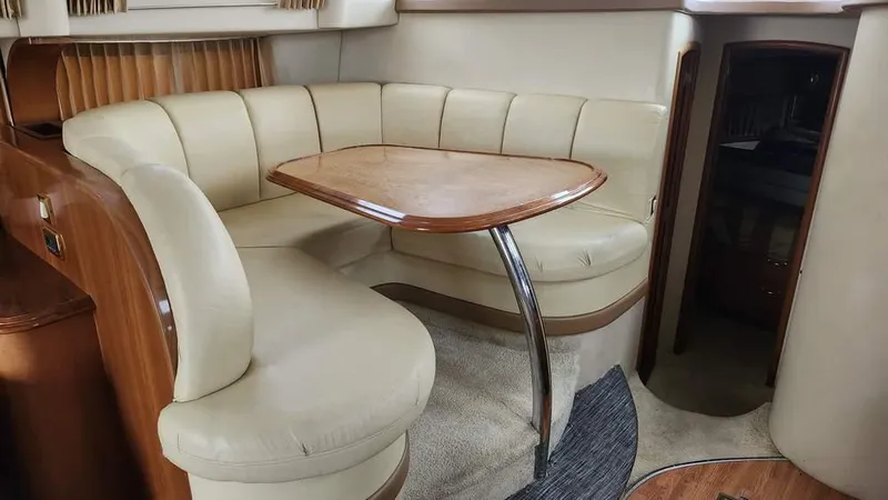  Yacht Photos Pics 2005 Carver 420 Mariner interior with beige leather seating and wooden table.