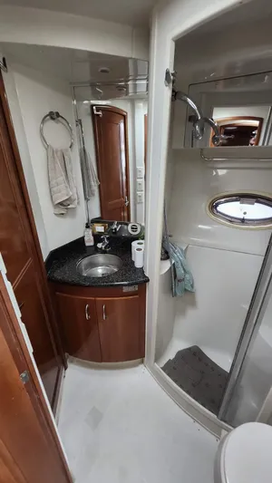  Yacht Photos Pics 2005 Carver 420 Mariner bathroom with sink, shower, and wooden cabinetry.