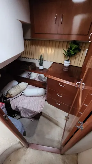  Yacht Photos Pics 2005 Carver 420 Mariner cabin interior with bed, plants, and wooden cabinetry.