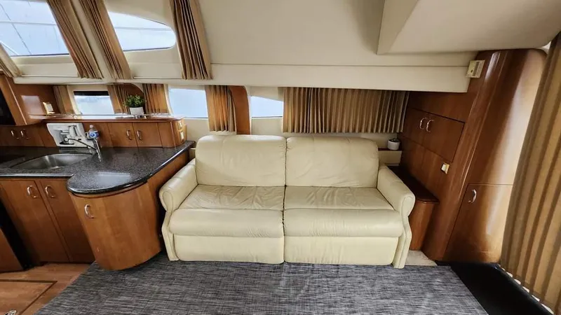  Yacht Photos Pics Interior of 2005 Carver 420 Mariner yacht with beige sofa and wooden cabinetry.