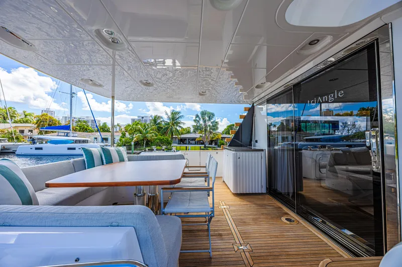  Yacht Photos Pics Luxurious Azimut Magellano 66 yacht deck with elegant seating, wooden flooring, and scenic marina view.