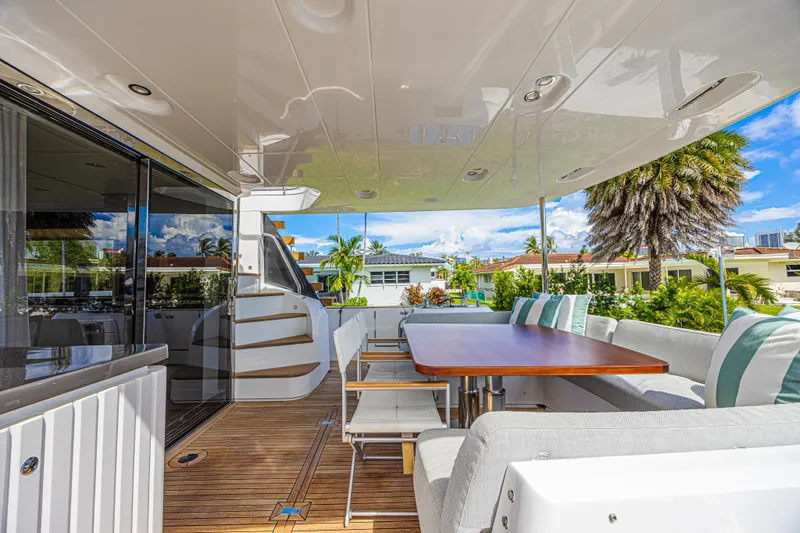  Yacht Photos Pics Luxurious 2022 Azimut Magellano 66 yacht deck with elegant seating and dining area.