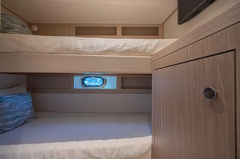  Yacht Photos Pics Interior of 2022 Azimut Magellano 66 yacht cabin with bunk beds and porthole.