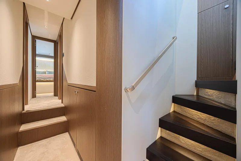  Yacht Photos Pics Luxurious interior of 2022 Azimut Magellano 66 yacht, featuring elegant wood finishes and modern staircase.
