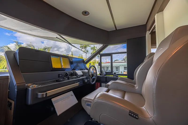  Yacht Photos Pics Interior helm of 2022 Azimut Magellano 66 yacht with modern controls and leather seating.