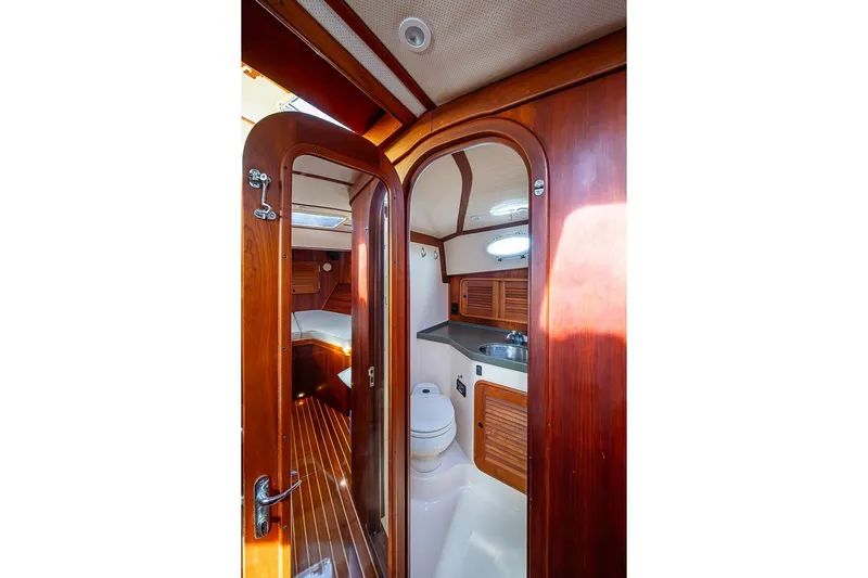 Miss Betty Yacht Photos Pics Interior of 2002 Hinckley Talaria 40 yacht, featuring wooden cabinetry and compact bathroom.