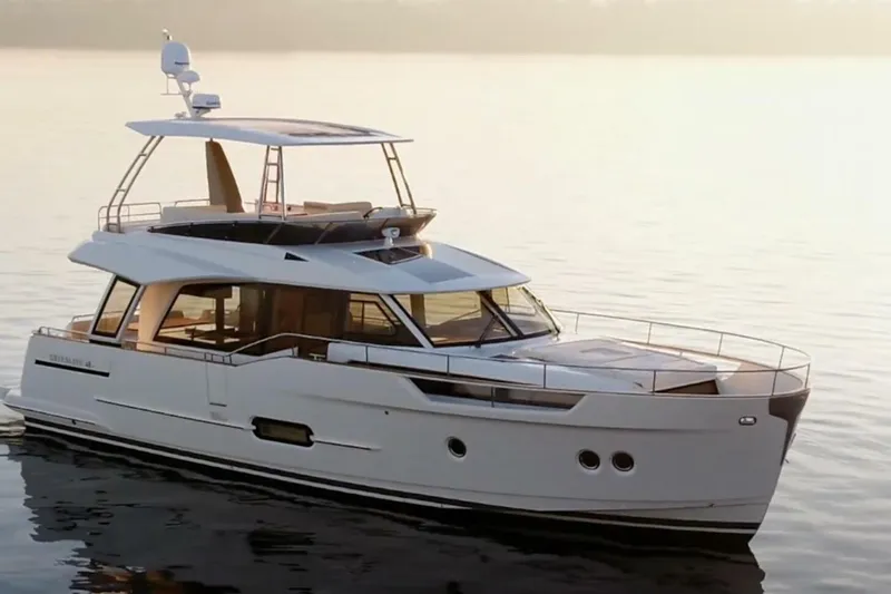 Tui Yacht Photos Pics 2023 Greenline 48 Fly yacht on calm water at sunset.