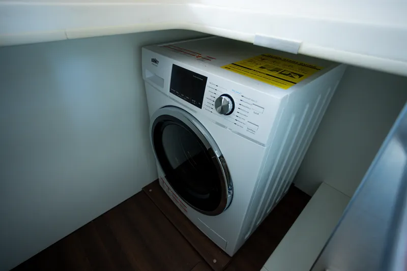 Tui Yacht Photos Pics Washing machine inside 2023 Greenline 48 Fly yacht, compact laundry area.