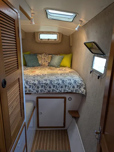  Yacht Photos Pics Cozy cabin interior of 2000 Manta 42 sailboat with bed, skylight, and wooden accents.