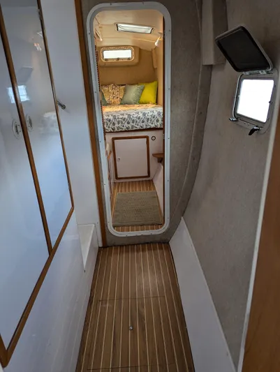  Yacht Photos Pics Narrow hallway in a 2000 Manta 42 yacht, leading to a cozy cabin with a bed.