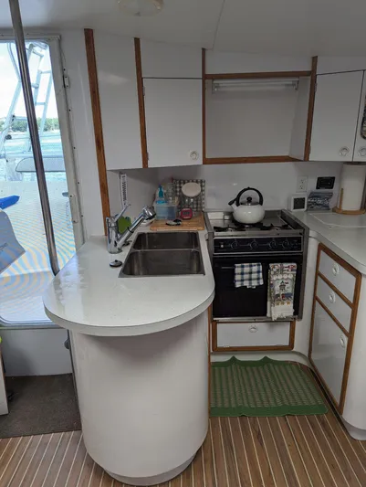  Yacht Photos Pics Compact kitchen in a 2000 Manta 42 yacht with modern amenities and wooden flooring.
