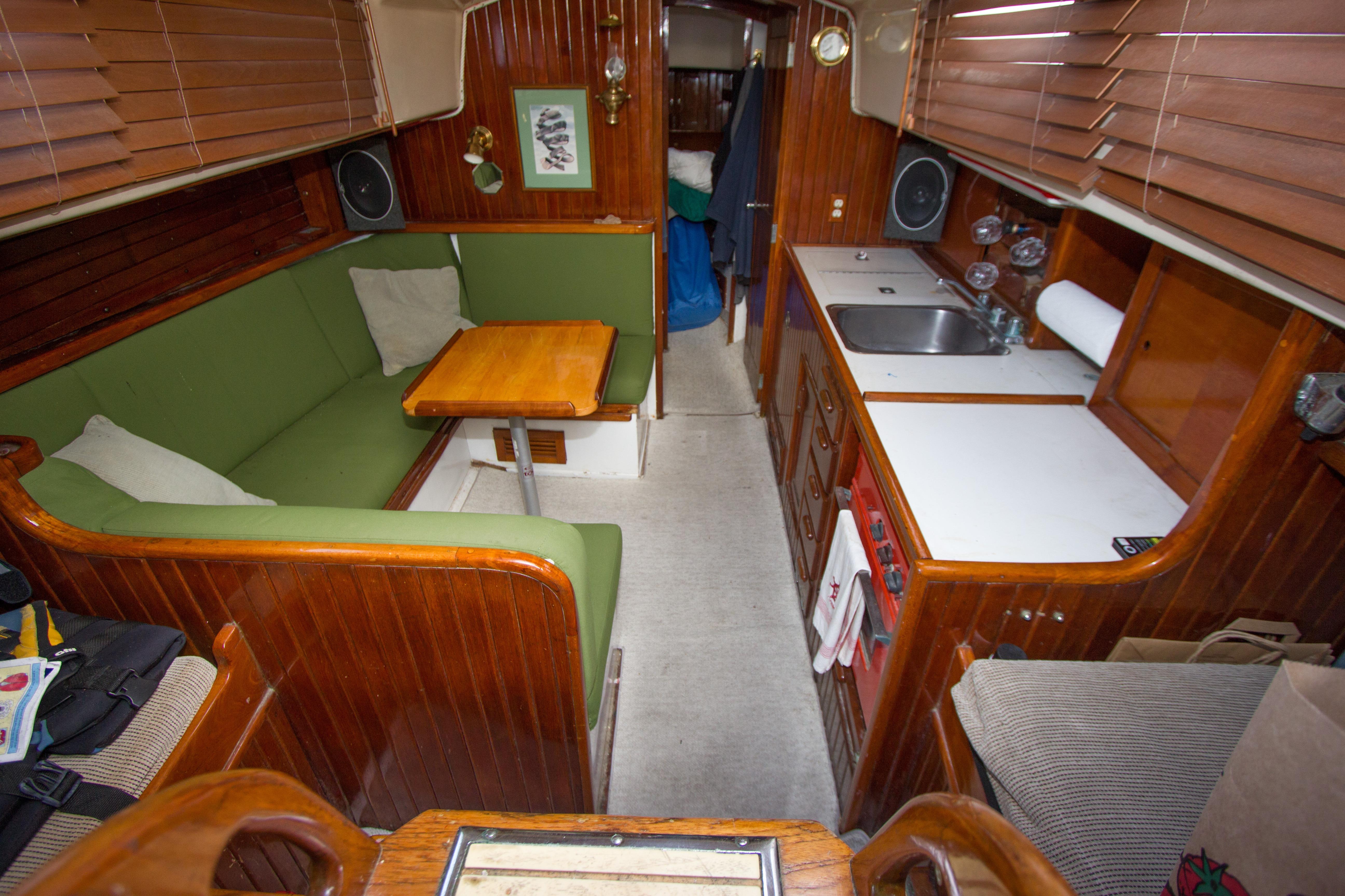 Interior of a 1965 Pearson Vanguard sailboat with wooden paneling and green seating.