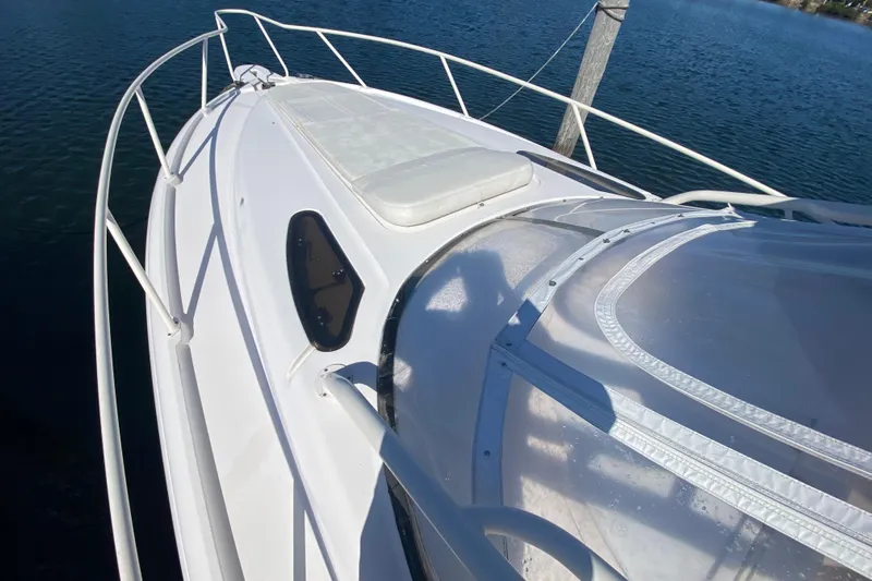  Yacht Photos Pics 2001 Intrepid 377 Walkaround boat deck with railing, docked on calm water.