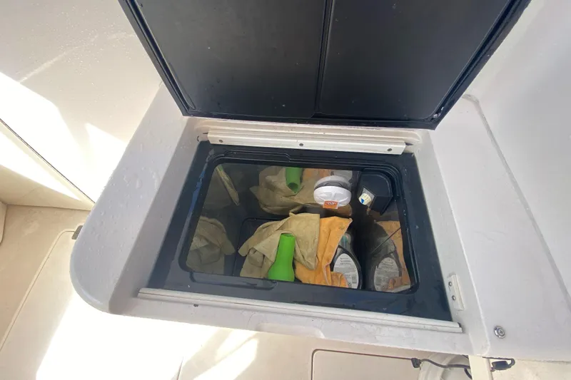  Yacht Photos Pics Storage compartment on a 2001 Intrepid 377 Walkaround boat, containing cleaning supplies.