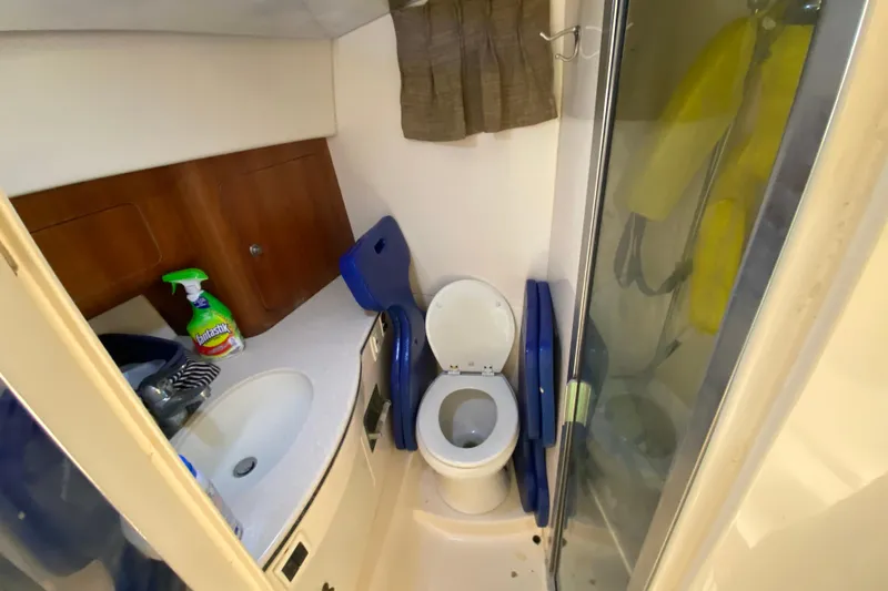  Yacht Photos Pics 2001 Intrepid 377 Walkaround boat bathroom with toilet, sink, and cleaning supplies.