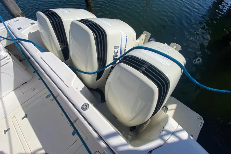  Yacht Photos Pics Triple outboard engines on a 2001 Intrepid 377 Walkaround boat, docked with blue ropes.