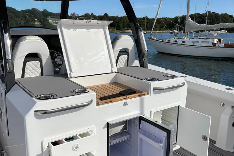 Hammercat 35-115 Yacht Photos Pics 2021 Hammer Yachts HammerCat 35 interior with open storage and seating, docked near sailboat.