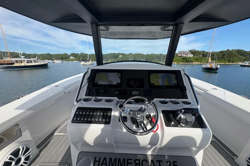 Hammercat 35-115 Yacht Photos Pics 2021 Hammer Yachts HammerCat 35 helm with navigation screens, steering wheel, and controls.