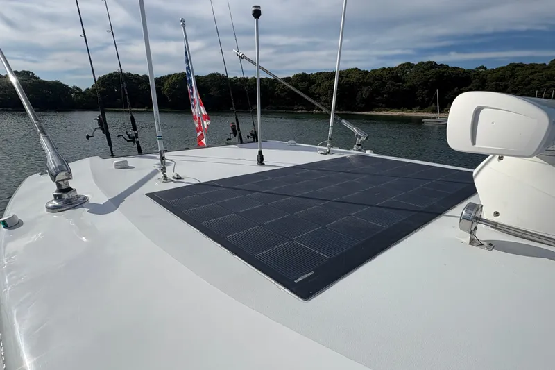 Hammercat 35-115 Yacht Photos Pics 2021 Hammer Yachts HammerCat 35 with solar panels on deck, docked by a forested shoreline.