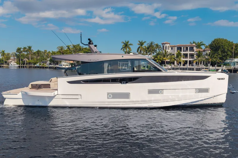  Yacht Photos Pics 2025 Azimut Seadeck 6 yacht on calm water, with luxury waterfront homes in the background.