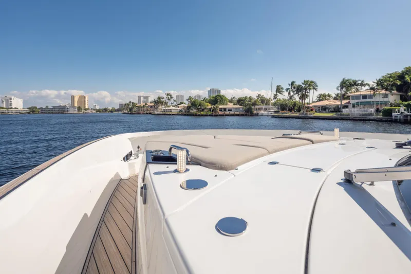  Yacht Photos Pics 2025 Azimut Seadeck 6 yacht cruising near waterfront homes under clear blue sky.