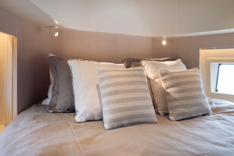  Yacht Photos Pics Luxurious bedroom interior of 2025 Azimut Seadeck 6 yacht with elegant pillows and soft lighting.