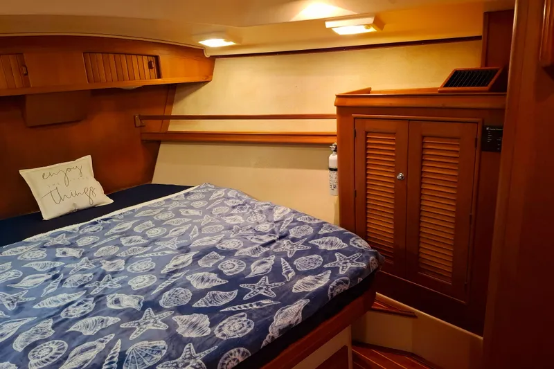 Priva Sea Yacht Photos Pics Cozy cabin interior of 2003 Island Packet 485 sailboat with nautical-themed bedding.