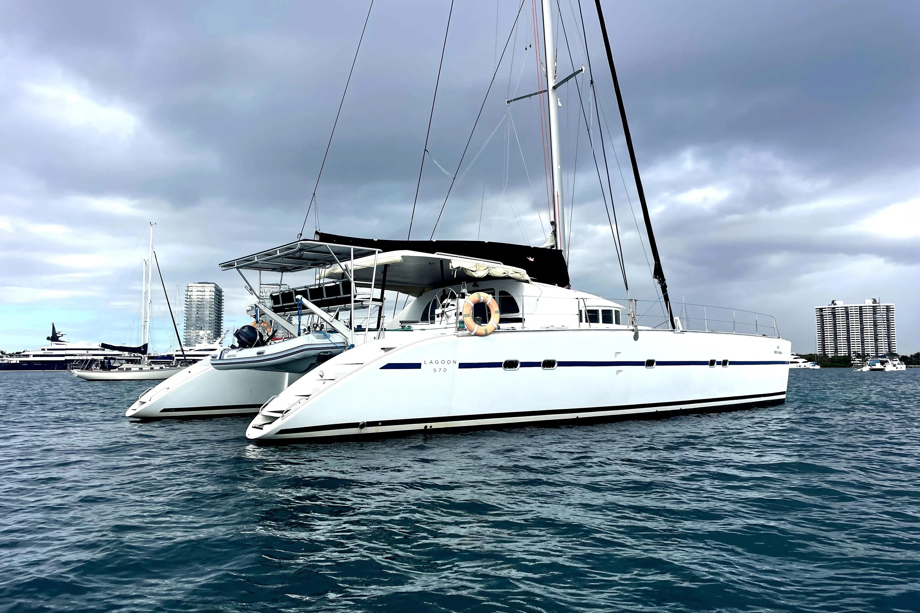 2004 Lagoon 570 catamaran sailing on calm waters under cloudy skies.