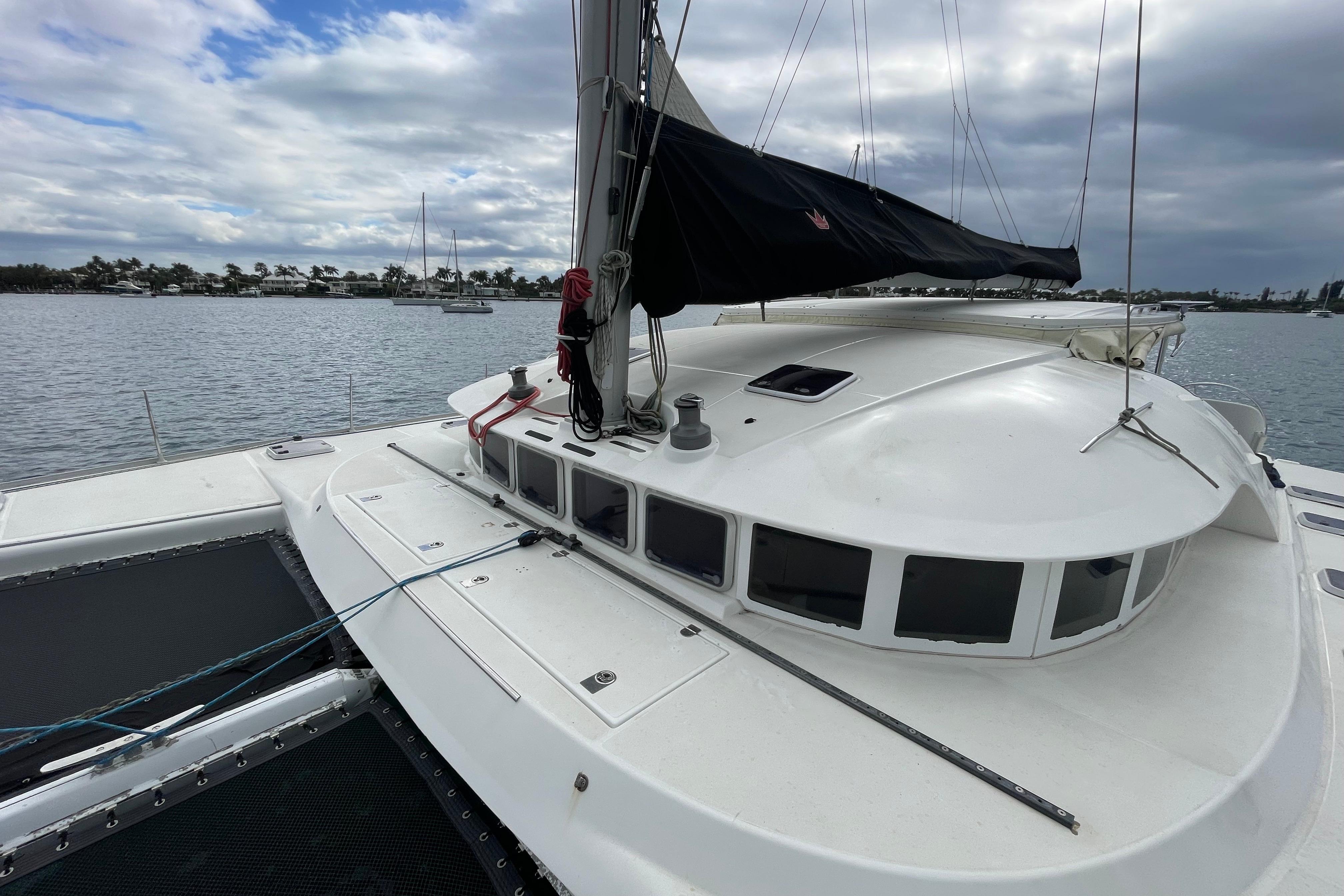2004 Lagoon 570 catamaran on calm waters under cloudy skies.