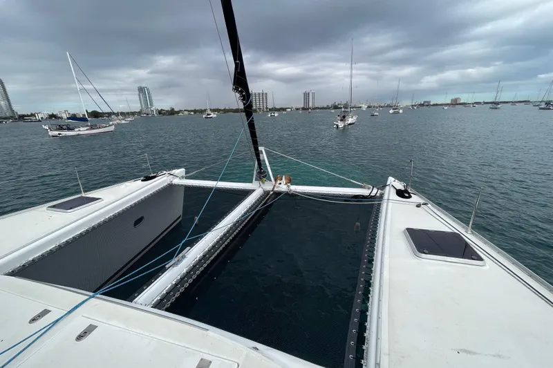 Futuna Yacht Photos Pics Lagoon 570 catamaran on water, overcast sky, city skyline in background, 2004 model.