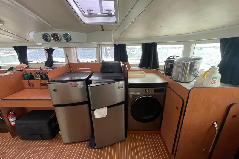 Futuna Yacht Photos Pics Interior of 2004 Lagoon 570 yacht with kitchen appliances and wooden cabinetry.