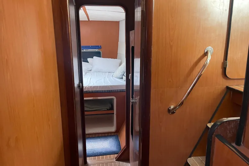 Futuna Yacht Photos Pics Interior cabin view of 2004 Lagoon 570 yacht, featuring cozy bed and wooden paneling.