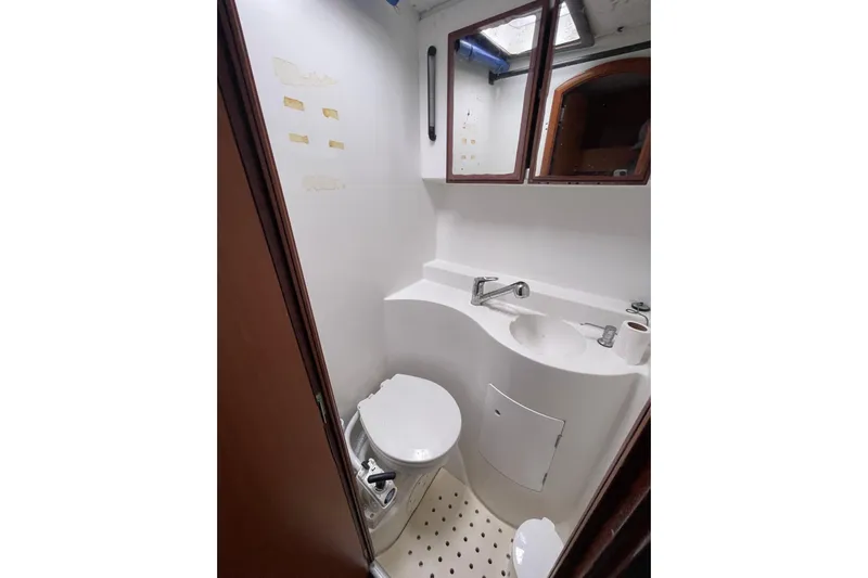 Futuna Yacht Photos Pics Compact bathroom in 2004 Lagoon 570 yacht with toilet, sink, and mirror.