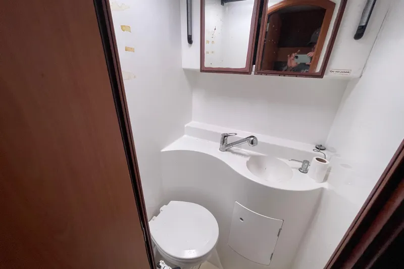 Futuna Yacht Photos Pics Compact bathroom in a 2004 Lagoon 570 yacht, featuring a sink, mirror, and toilet.