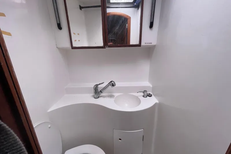Futuna Yacht Photos Pics Compact bathroom in a 2004 Lagoon 570 yacht with sink, mirror, and toilet.