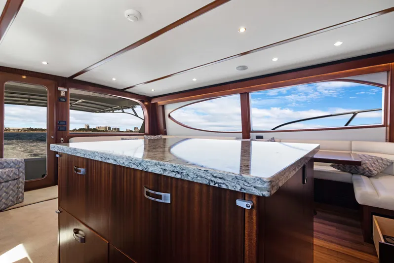  Yacht Photos Pics Luxurious interior of 2016 Hatteras 63GT yacht with elegant wood finishes and panoramic windows.