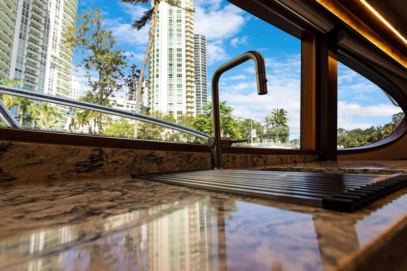  Yacht Photos Pics Luxurious Hatteras 63GT yacht interior with modern sink, cityscape view through window.