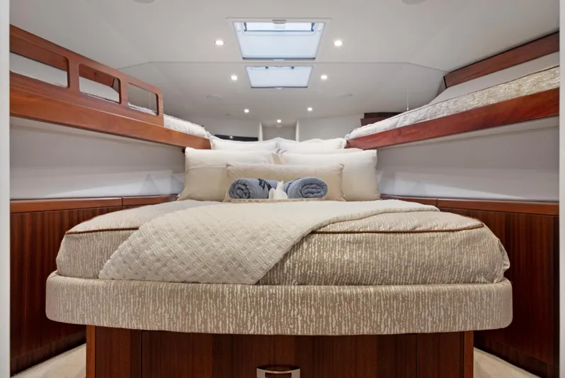  Yacht Photos Pics Luxurious cabin interior of 2016 Hatteras 63GT yacht with plush bedding and elegant wood finishes.
