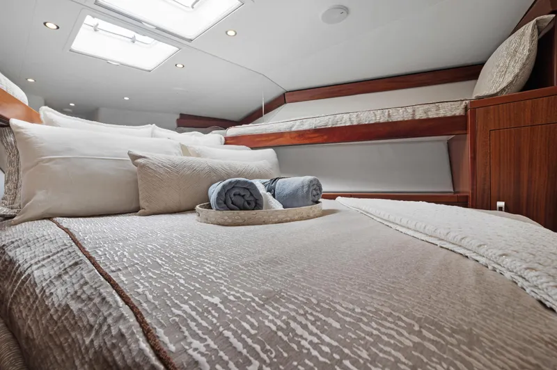  Yacht Photos Pics Luxurious cabin interior of 2016 Hatteras 63GT yacht with elegant bedding and natural light.